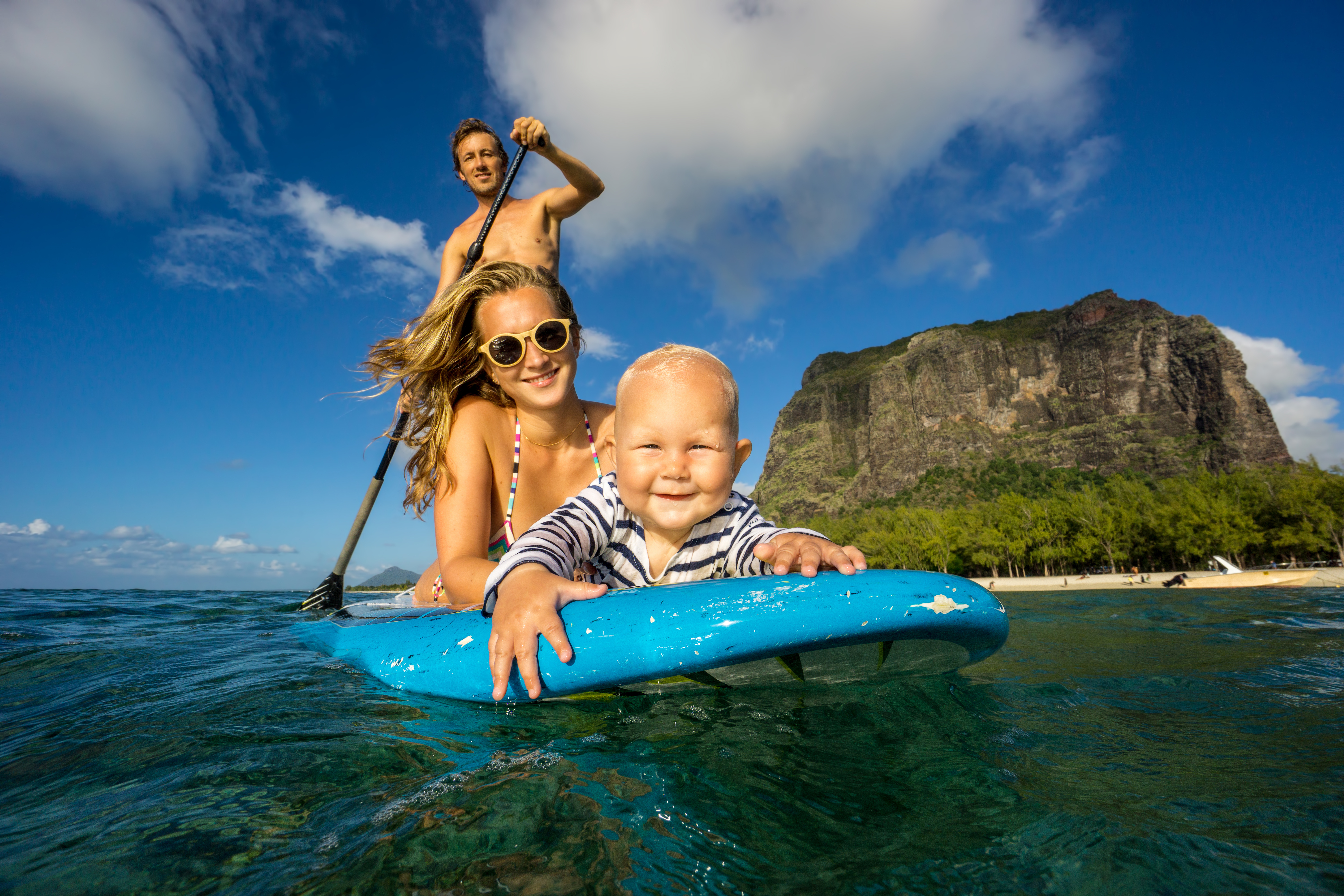 Young,And,Beautiful,Parents,Ride,By,Surfboard,With,Baby,In