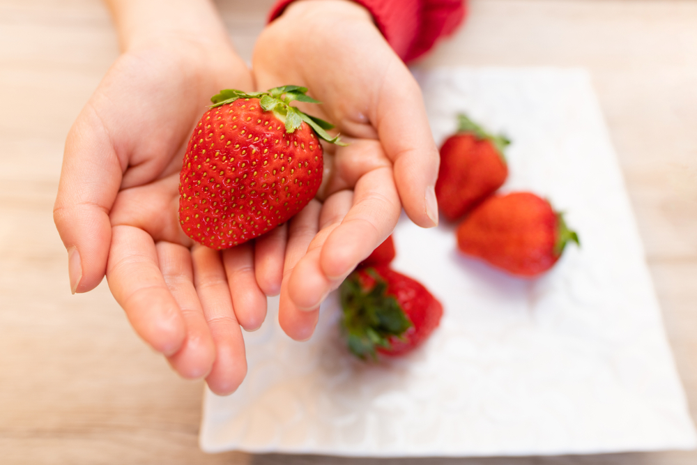 Child,Holds,Fresh,Strawberries,In,Hand